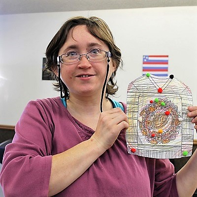 A STEP client proudly displays her finished art project.