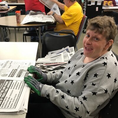 An employee readies the newspaper for shredding and use in STEP Firestarters