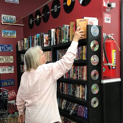 An employee shelves books at the STEP on in Thrift store in Staples.